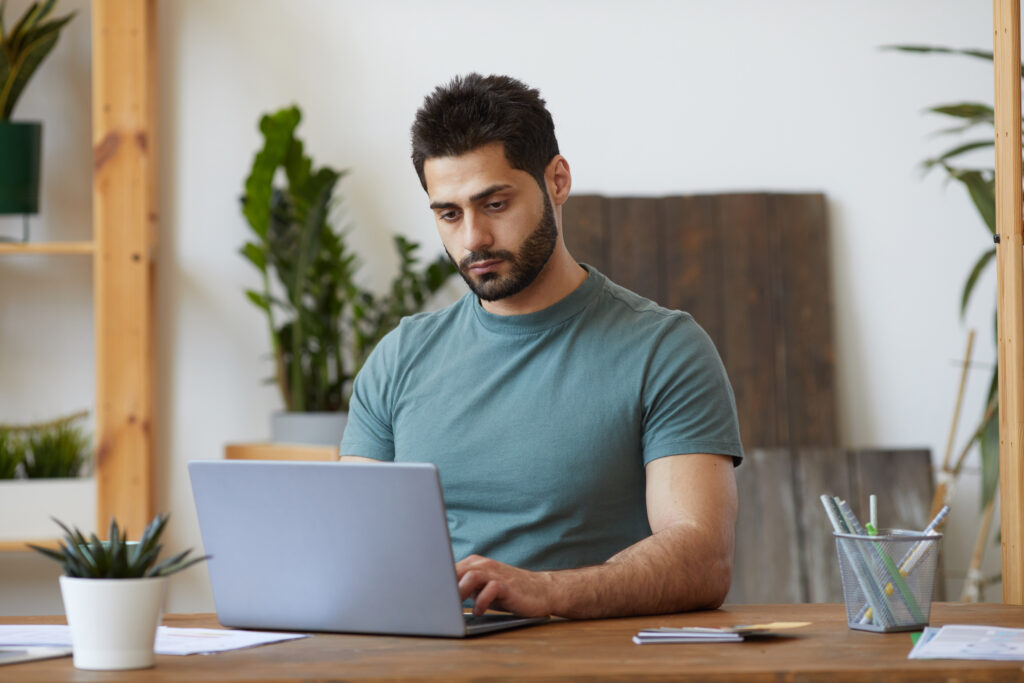Bearded Man using laptop at Home Office