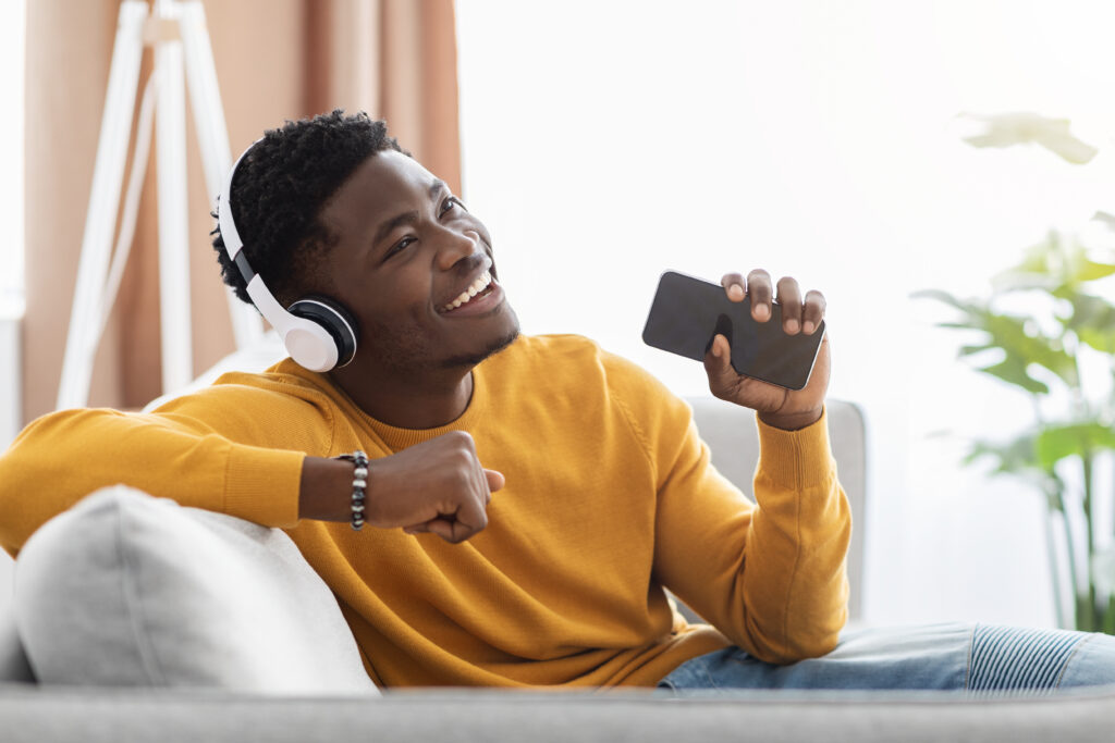 Carefree african american man listening to music on mobile phone